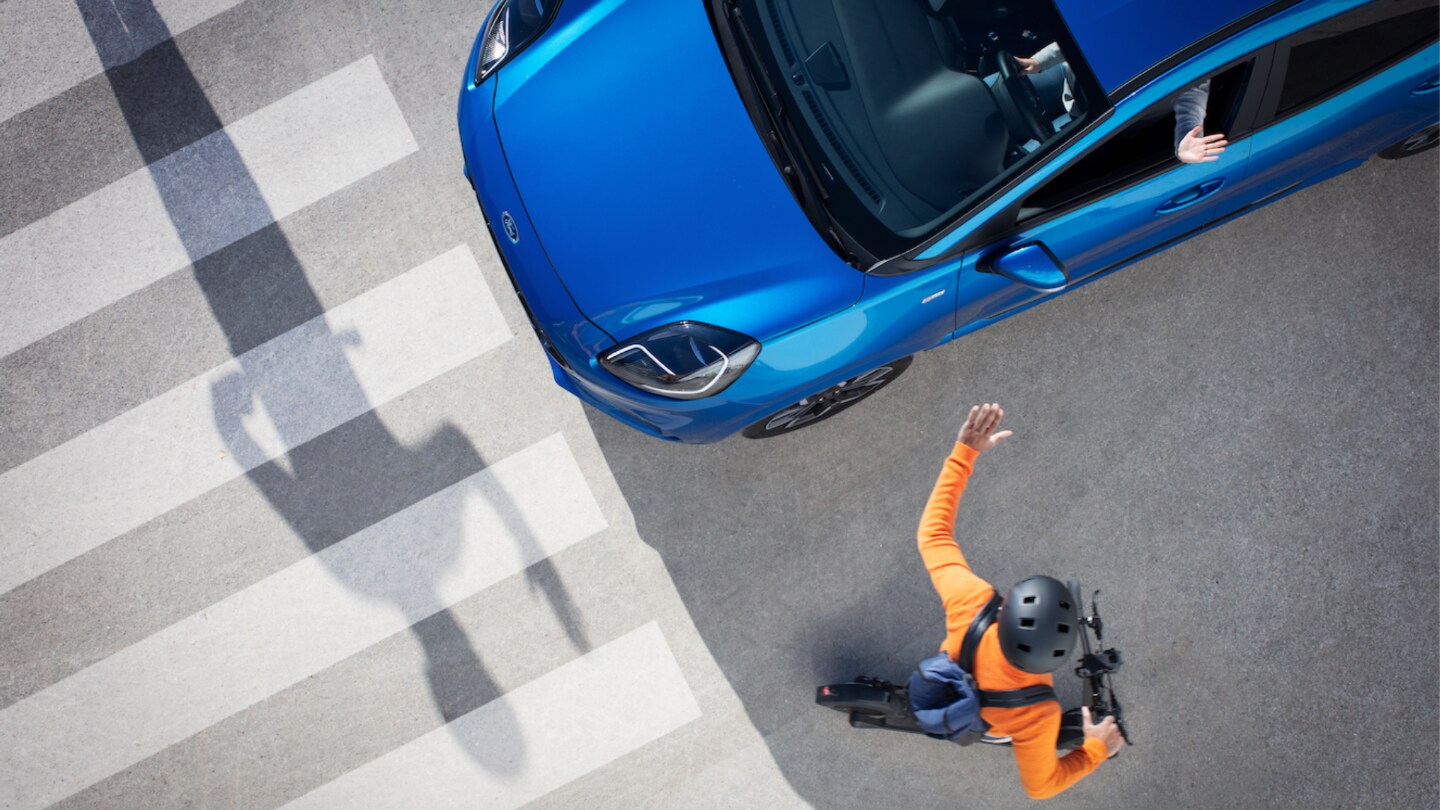 cyclist waving at car