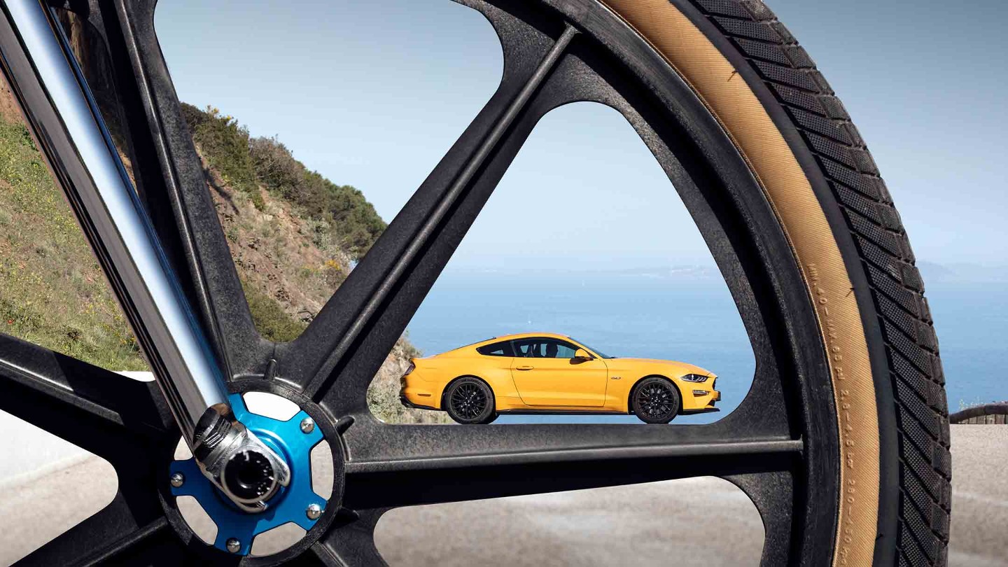 Yellow Ford Mustang through bike spokes