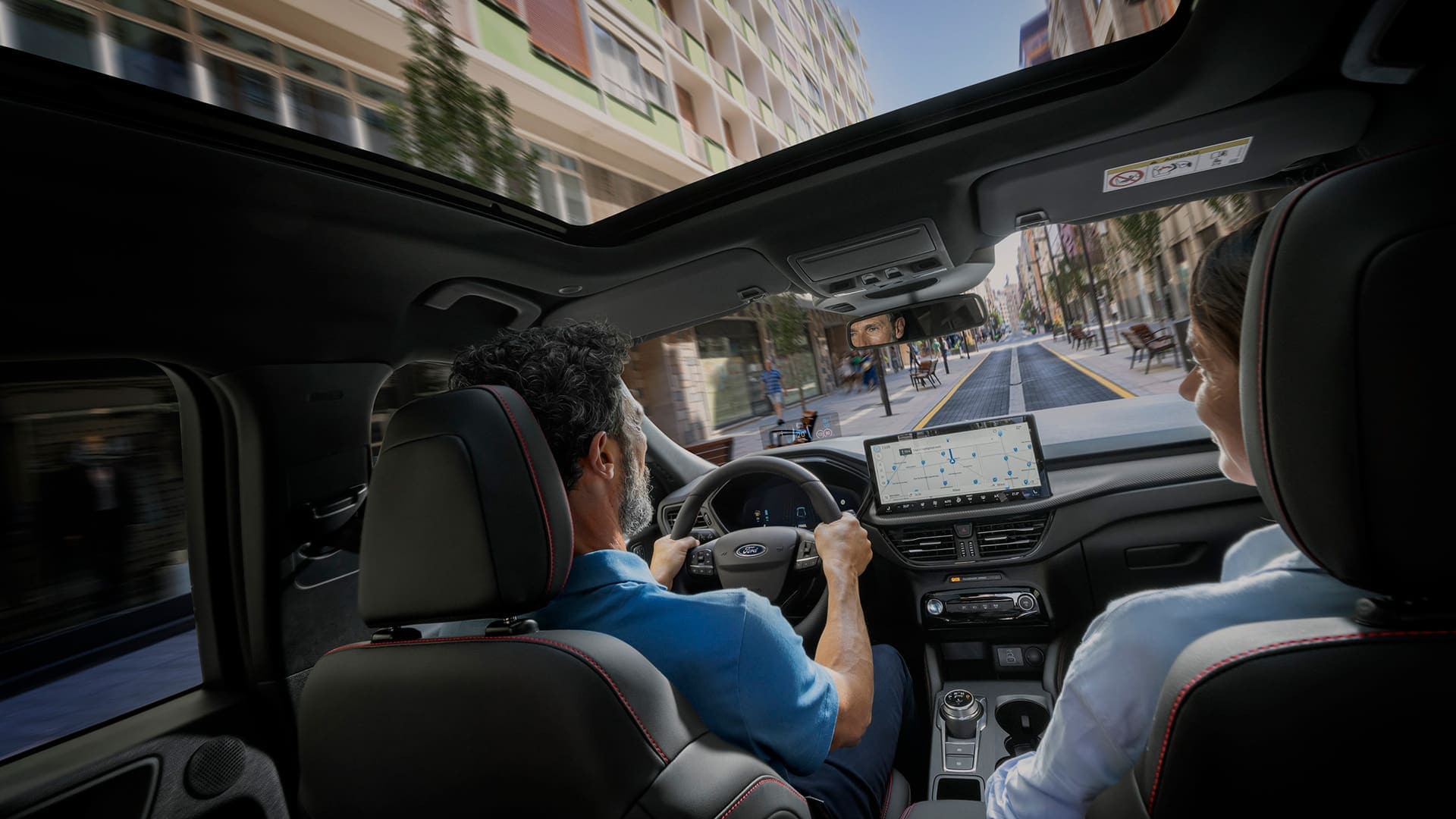 Passageiros num veículo Ford com o ecrã digital SYNC exibido para ajudar a navegar num percurso na cidade.