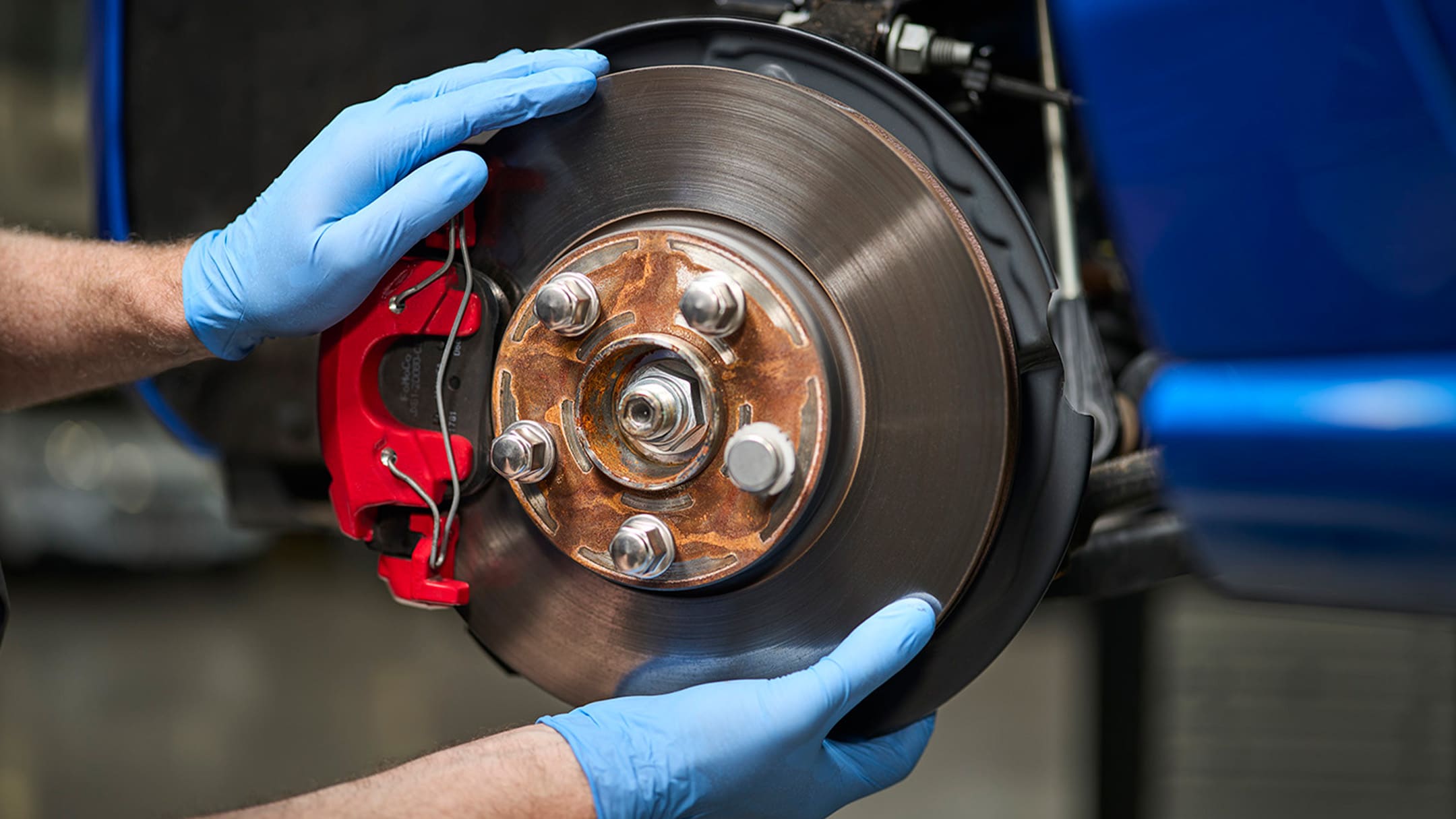 Um mecânico segura uma peça genuína Ford durante um serviço e reparação Ford.