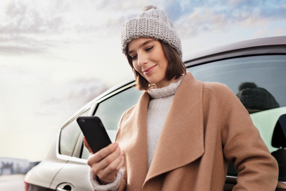 Mulher a sorrir enquanto olha para o smartphone