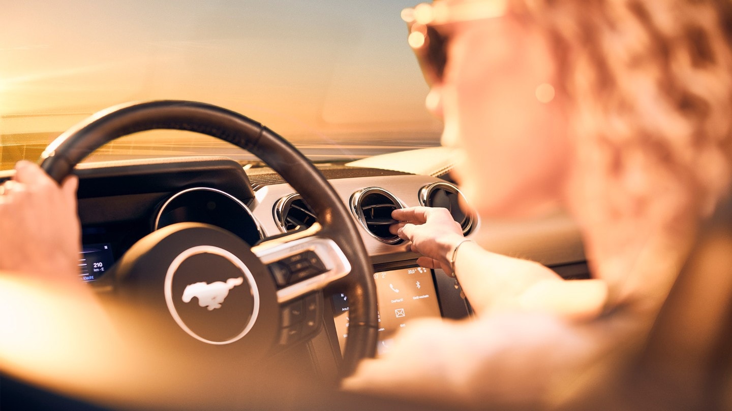 A woman driving Mustang