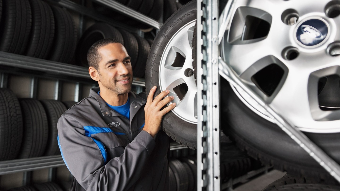 Mecânico da Ford a agarrar num oneu